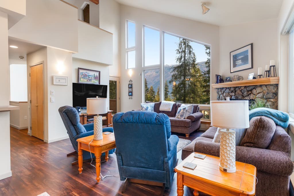 Penguin Ridge sits directly across the valley—and from the private deck of this peaceful family cabin, it completely owns the view. Enclosed by mature spruce and hemlock, this property feels completely isolated from the rest of the world while sitting less than a mile from the Alyeska Resort Day Lodge and Girdwood’s village center. The cabin architecture features high windows that flood the rustic interior with natural light, a ceramic log fireplace that anchors the open family living room, and a massive upstairs sleeping loft that easily handles extra guests and kids. Spend your days exploring the Chugach wilderness, and your nights soaking in the private hot tub under the trees. Standard Specs: Fully equipped kitchen, private outdoor hot tub, ceramic log fireplace, sleeping loft, private washer/dryer, flat-screen TV, high-speed WiFi, and hospitality check-in instructions. Driveway parking for up to four vehicles. Strict quiet hour compliance (10 PM–8 AM). Non-smoking. Sleeps 10.