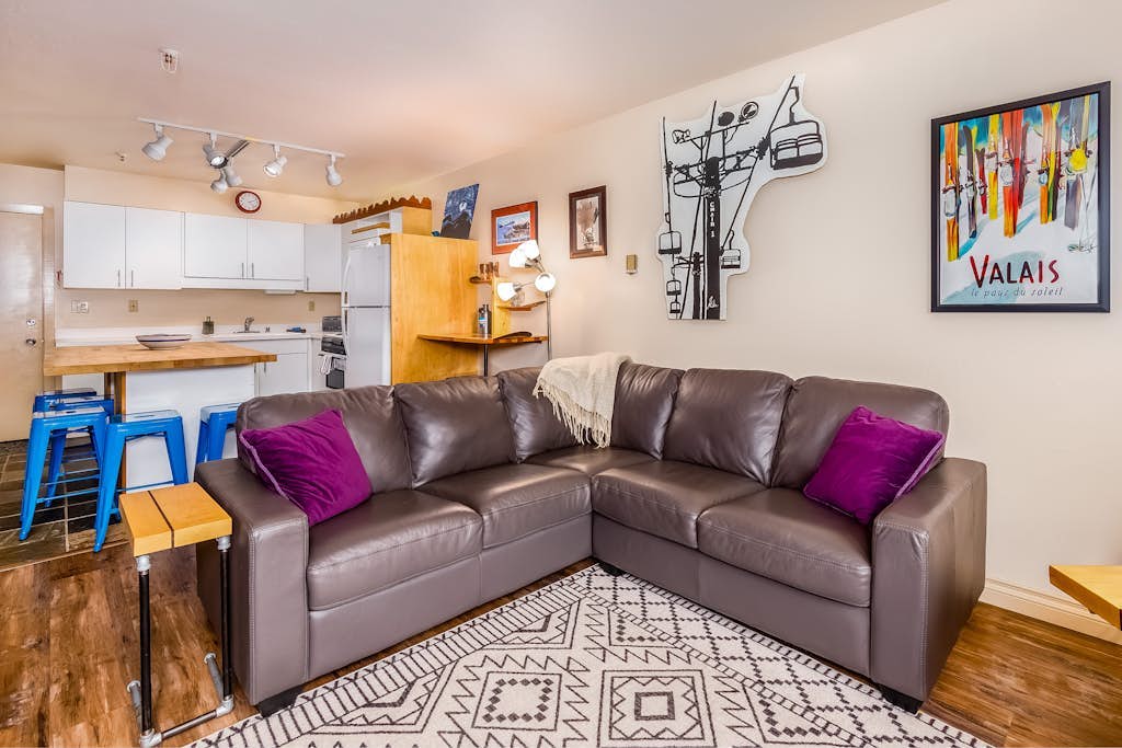 The centerpiece of this premium slopeside condo is an iconic 360-degree fireplace that sits directly in the middle of the open living room, radiating warmth throughout the entire space. Boasting uncompromised full mountain views and true ski-in/ski-out lift access, this one-bedroom-plus-loft condo sits right in the heart of Alaska's ski country. The bright, welcoming interior features a private deck for morning coffee or apres-ski drinks, a well-appointed kitchen, and smart entertainment streams. Positioned directly on the Girdwood shuttle line, the property offers quick walking access to the resort spa facility, trailheads, and valley fine dining. Shared building laundry is located inside the complex. Standard Specs: Full kitchen, 360-degree center fireplace, private viewing deck, flat-screen Smart TV, high-speed WiFi, and keypad entry. Dedicated parking for one vehicle. On-site shared laundry. True ski-in/ski-out. Sleeps 4.