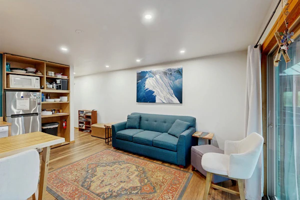 Clean design meets mountain utility. Sea to Ski Escape is a minimalist Girdwood studio condo located near the base of Alyeska Resort, engineered to let the massive surrounding landscape do the talking. The clean interior footprint trades clutter for comfort, providing a full kitchen, a private viewing deck with mountain views, and a queen-bed-plus-pull-out layout that easily handles up to four guests. Located inside a highly secured building within walking distance of the village restaurants, the condo includes a reserved parking spot and direct access to a communal building sauna. Standard Specs: Fully equipped kitchen, private viewing deck, flat-screen TV/DVD, high-speed WiFi, keypad entry, and shared building sauna/coin laundry access. Secured building with one reserved parking spot. True ski-in/ski-out access in winter. Sleeps 4.