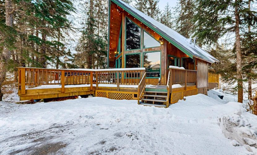 Some properties are styled to look like old Girdwood. This one actually is Girdwood. Preserving the architectural culture of the valley's early ski days, this classic A-frame chalet features original open-beam wood interiors, towering windows, and an open floor plan that lets the mountain light all the way in. Modern updates are placed thoughtfully where they matter most—including a reliable gas heating stove and a traditional, wood-powered cedar barrel sauna right outside the front door to handle muscle recovery. Located in an established neighborhood close to the hill, it sits directly on the paved path running toward Virgin Creek Falls trailhead. Standard Specs: Full kitchen with dishwasher, private washer/dryer, flat-screen TV, high-speed WiFi, and keypad entry. Dedicated parking for two vehicles. Guests can easily purchase firewood for the sauna locally. Sleeps 5.