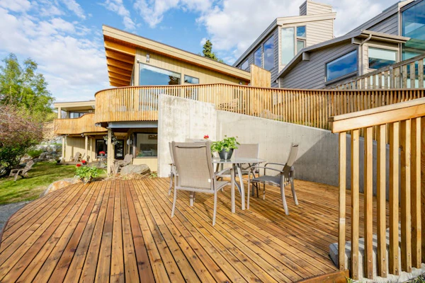 This high-utility group rental combines two independent, private-entry condos within the luxury M Street downtown Anchorage triplex into a single, connected three-bedroom configuration via a shared outdoor alcove patio. It is the perfect operational call when you need more scale than a single unit but don't require the full property compound. The interior showcases sleek industrial finishes, a built-in gas fireplace, a full kitchen plus an independent second kitchenette, and a master suite with walk-out access to the large garden patio. Outside, the grounds offer two completely private hot tubs and a shared landscaped garden looking out over Cook Inlet and Mt. Denali on clear days. Walk to the Coastal Trail and downtown eateries. Standard Specs: Full kitchen plus independent kitchenette, built-in gas fireplace, two private outdoor hot tubs, shared garden patio with gas grill, flat-screen TVs, high-speed WiFi, and keypad entry. Off-street parking for two vehicles. Involves a long entryway stairwell. Sleeps 9.