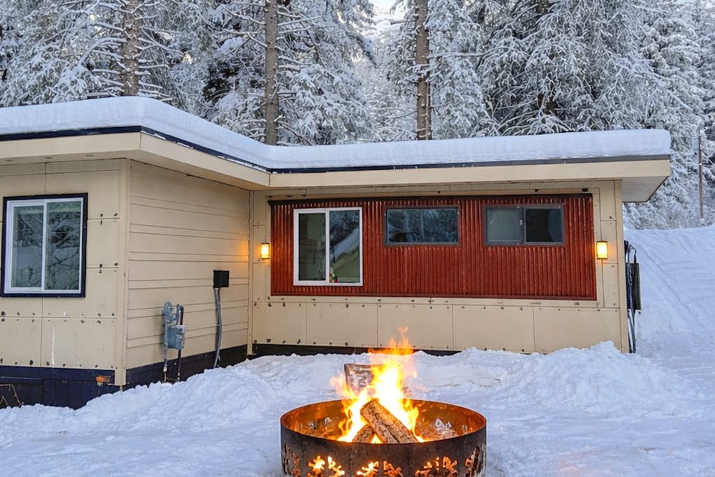 A standard shipping container turned into a high-end alpine cottage, creating one of the most architecturally unique and interesting stays in the Girdwood valley. Blending sleek industrial elegance with cozy mountain utility, this home offers alpine views from massive scenic windows that flood the custom layout with light. The interior features a master queen bedroom, a comfortable living room sleeper sofa, and a fully equipped modern kitchen with a dishwasher. Positioned just minutes from Alyeska Resort and within short walking distance of the world-famous Double Musky Inn restaurant, this cottage proves great design can come from anywhere. Standard Specs: Fully equipped kitchen with dishwasher, large scenic windows, flat-screen TV with Netflix streaming, high-speed Starlink WiFi, and keypad entry. Dedicated parking for two vehicles. Walking distance to Double Musky Inn. Sleeps 4.