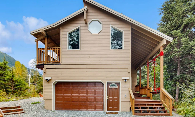 Sprawling across four distinct structural floors and completely enclosed by a serene, old-growth spruce forest, Vail Meadows Chalet is the ultimate four-season mountain basecamp. Located a short half-mile walk from world-famous Alyeska Resort, this commanding home handles large group campaigns with total ease. Winter trips focus around an authentic wood stove, an indoor private dry sauna, and direct slope access for fat-tire biking or skiing. Long summer days center around a private stone patio and fire pit with completely unobstructed mountain views, surrounded by high-bush blueberry and salmonberry bushes. Features a cozy loft, multiple king suites, a custom bunk room, and children's amenities. Standard Specs: Fully equipped kitchen, private indoor dry sauna, outdoor stone patio with fire pit, wood stove, covered viewing deck, child's high chair/Pack-N-Play, Smart TV, board games, high-speed WiFi, and keypad entry. Driveway parking for three vehicles on a quiet cul-de-sac. Sleeps 8.