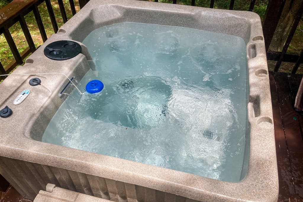 Delightful creekside cabin w/ spacious deck, private hot tub, fire pit, & views