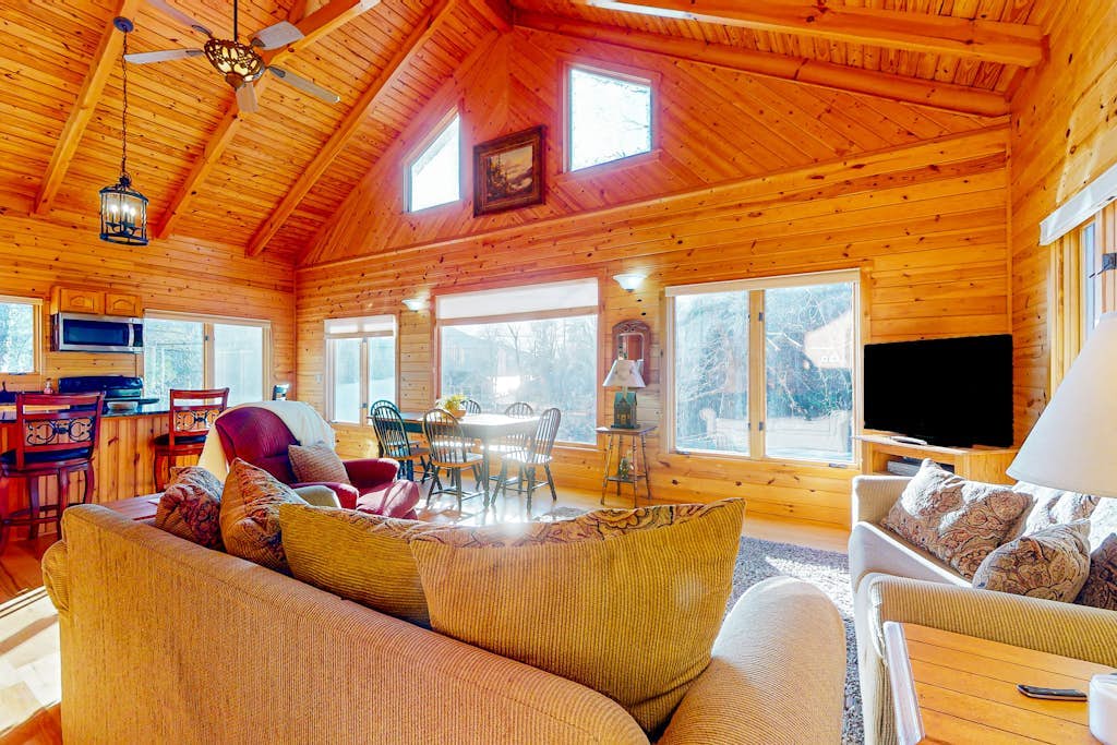 Rustic two-story lakefront cabin near beach with dock, lake & mtn views, & deck