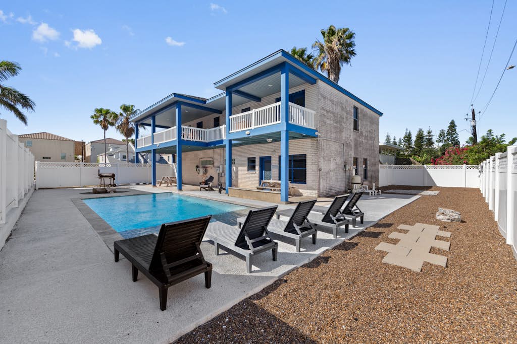 Welcome to Paradise on Padre, a bright two-story island home on the beach side of South Padre with a private fenced pool, a fountain-fed tanning shelf, and the sand a short walk away. Upstairs, an open living, kitchen, and dining space flows to a wrap-around balcony with pool and water views, while a downstairs game room brings foosball, billiards, and a kitchenette. With room for up to 18 guests across three bedrooms, it is made for big families to gather, play, and unwind by the water.
