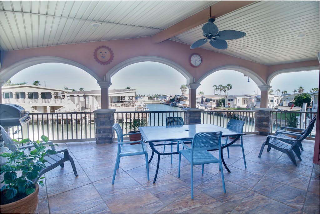 Welcome to Copper Bottom Cottage, a four-bedroom waterfront retreat in the channels of gated Long Island Village. Gather on the spacious covered deck above the canal, fish from the water's edge, and spread out across two levels with room for eight. The lower unit has its own entrance, and every bedroom has a streaming TV. Your stay includes the community's indoor and outdoor pools, hot tubs, par-3 golf, tennis, and marina, with South Padre Island beaches about ten minutes over the causeway.