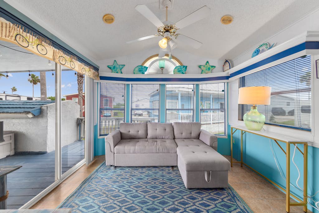 Welcome to Blue Paradise, a bright and breezy one-bedroom cottage tucked inside the gated Long Island Village resort in Port Isabel. Sink into the sunroom-style living room wrapped in windows, cook in the cheerful coastal kitchen, and unwind on your covered deck. Your stay unlocks the resort's pools, hot tubs, golf, tennis, and more, with South Padre Island's beaches just ten minutes across the causeway. Sleeps four, and your dog is welcome too.