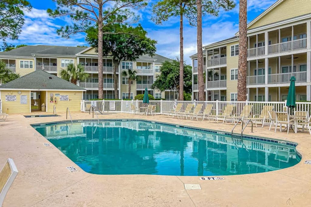 Bright and spacious condo with resort amenities, water views, balcony, & AC
