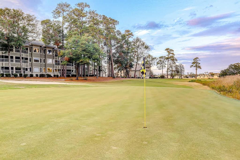 Secluded golf course front condo with porch, pool, tennis, hot tub, gym, & AC
