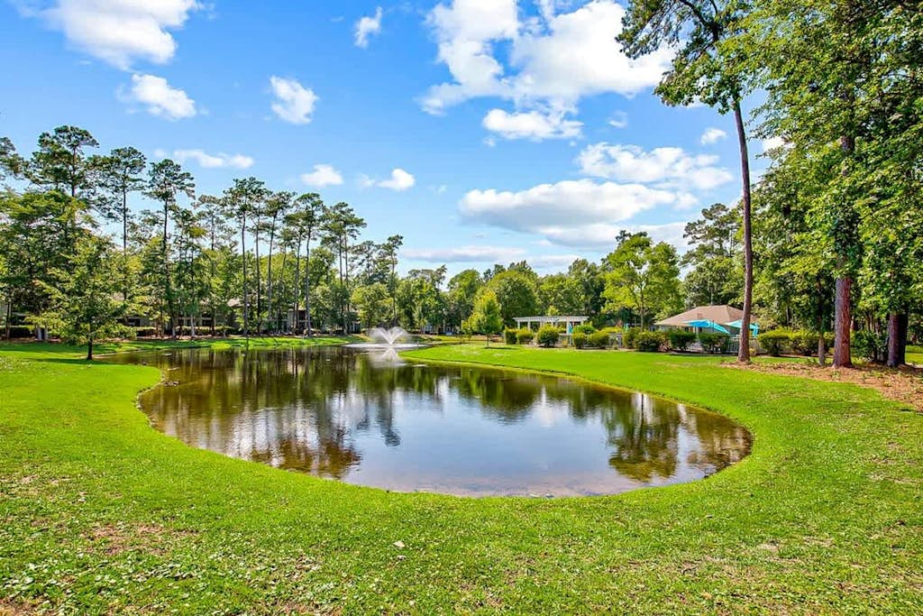 Secluded golf course front condo with porch, pool, tennis, hot tub, gym, & AC