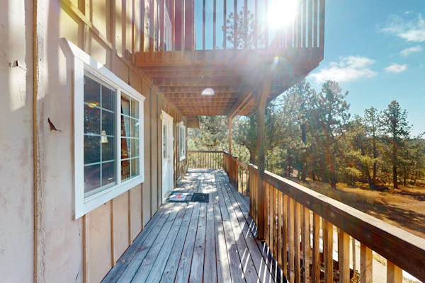 A-frame home lined by trees with wood stove, balcony, children's items, & W/D