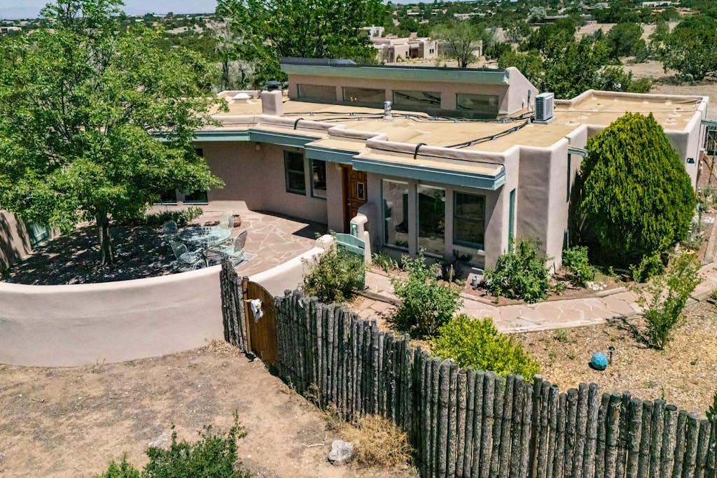 Casa de Colores is a charming high-desert retreat on over an acre just outside Santa Fe, with exposed wood beams, mountain views, and beautiful New Mexico sunrises and sunsets. Enjoy coffee on the shaded patio, comfortable interiors with AC, and a second living area. Sleeps 4 with 2 bedrooms, 2 baths, and is just 20 minutes from the Santa Fe Plaza. Traveling with a dog? The fully fenced yard even has a playful window at dog height.