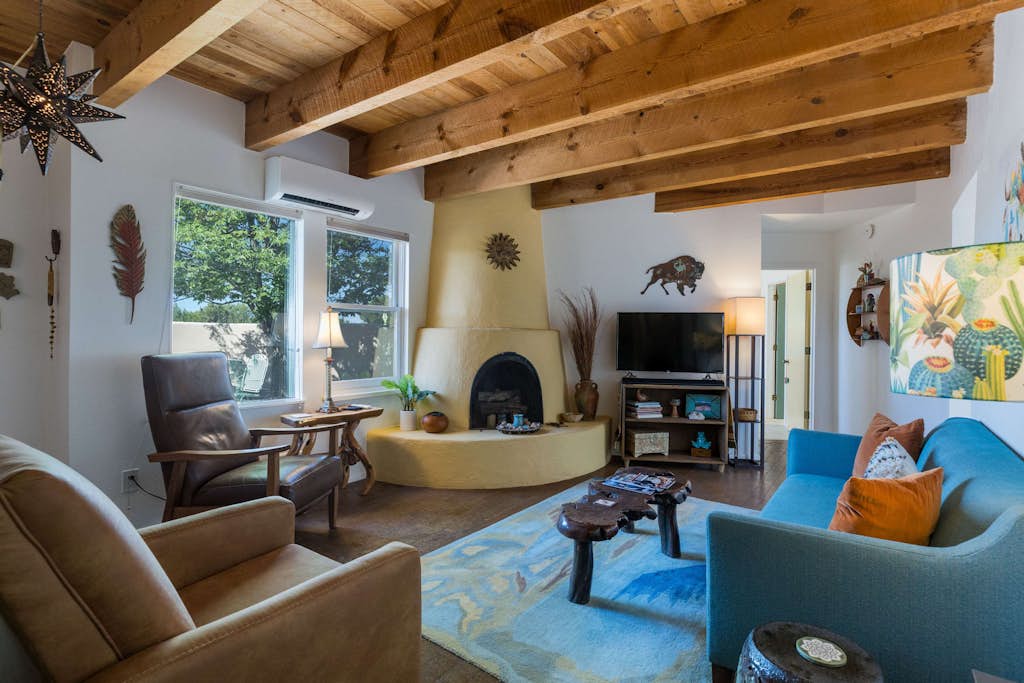 Casa de Colores is a charming high-desert retreat on over an acre just outside Santa Fe, with exposed wood beams, mountain views, and beautiful New Mexico sunrises and sunsets. Enjoy coffee on the shaded patio, comfortable interiors with AC, and a second living area. Sleeps 4 with 2 bedrooms, 2 baths, and is just 20 minutes from the Santa Fe Plaza. Traveling with a dog? The fully fenced yard even has a playful window at dog height.