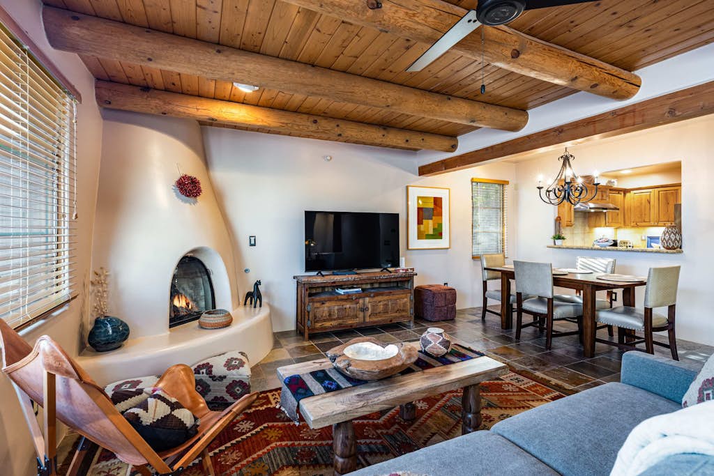 Welcome to Casita Sol, your adobe retreat in the heart of downtown Santa Fe. Step through a private entrance and up to a light-filled great room where viga ceilings, a glowing kiva fireplace, and handwoven rugs set an unmistakably Southwestern mood. Sip morning coffee on your private deck, wander to the Plaza in minutes, then return to cook, gather, and unwind. With central air, a king suite, and room for six, Casita Sol is your easy, authentic home base for the City Different.