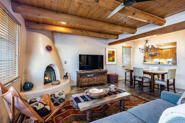 Welcome to Casita Sol, your adobe retreat in the heart of downtown Santa Fe. Step through a private entrance and up to a light-filled great room where viga ceilings, a glowing kiva fireplace, and handwoven rugs set an unmistakably Southwestern mood. Sip morning coffee on your private deck, wander to the Plaza in minutes, then return to cook, gather, and unwind. With central air, a king suite, and room for six, Casita Sol is your easy, authentic home base for the City Different.