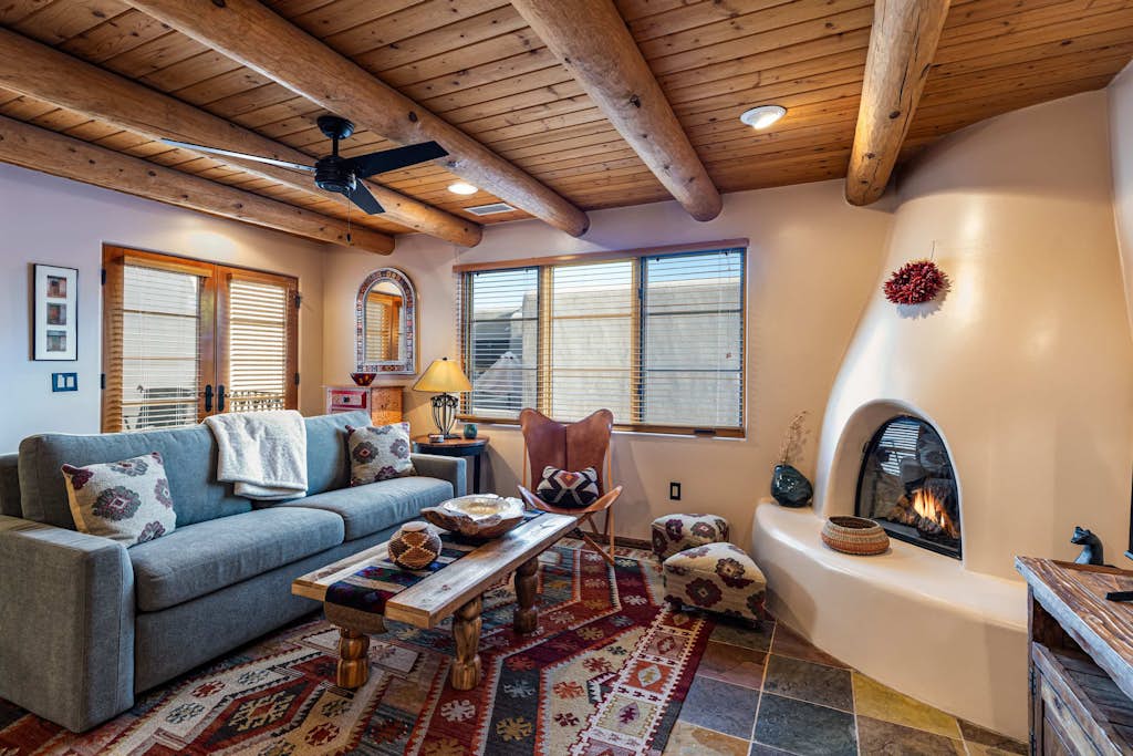 Welcome to Casita Sol, your adobe retreat in the heart of downtown Santa Fe. Step through a private entrance and up to a light-filled great room where viga ceilings, a glowing kiva fireplace, and handwoven rugs set an unmistakably Southwestern mood. Sip morning coffee on your private deck, wander to the Plaza in minutes, then return to cook, gather, and unwind. With central air, a king suite, and room for six, Casita Sol is your easy, authentic home base for the City Different.